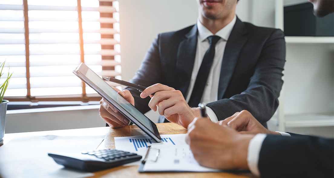 Ausschnitt Geschäftsmänner mit IPad symbolisieren Ertragswertverfahren